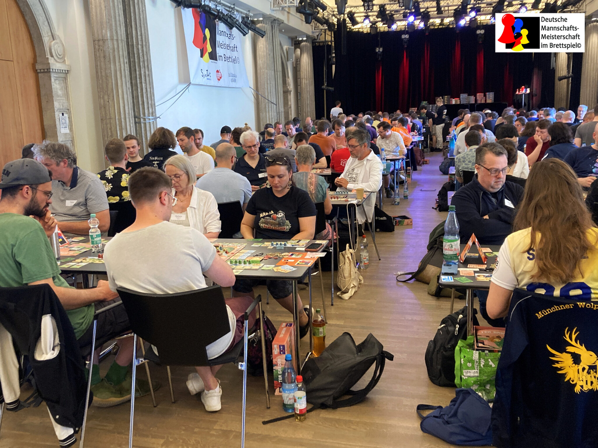 Le file di tavoli della finale del campionato tedesco a squadre 2026, con le squadre in partita sotto lo striscione della DMMiB