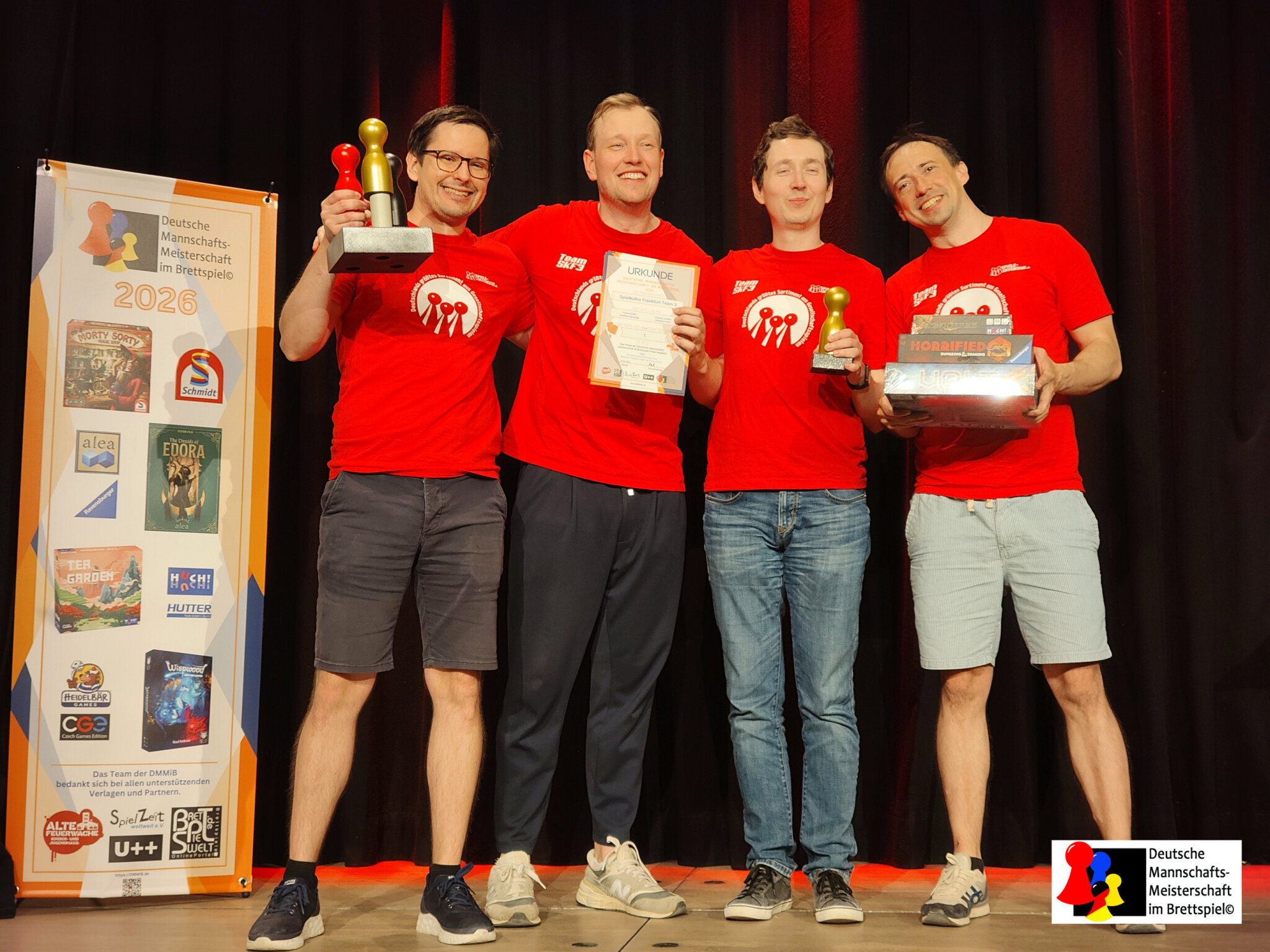 I quattro giocatori di Spielkultur Frankfurt Team 3 sul palco con il trofeo e il diploma di campioni di Germania 2026