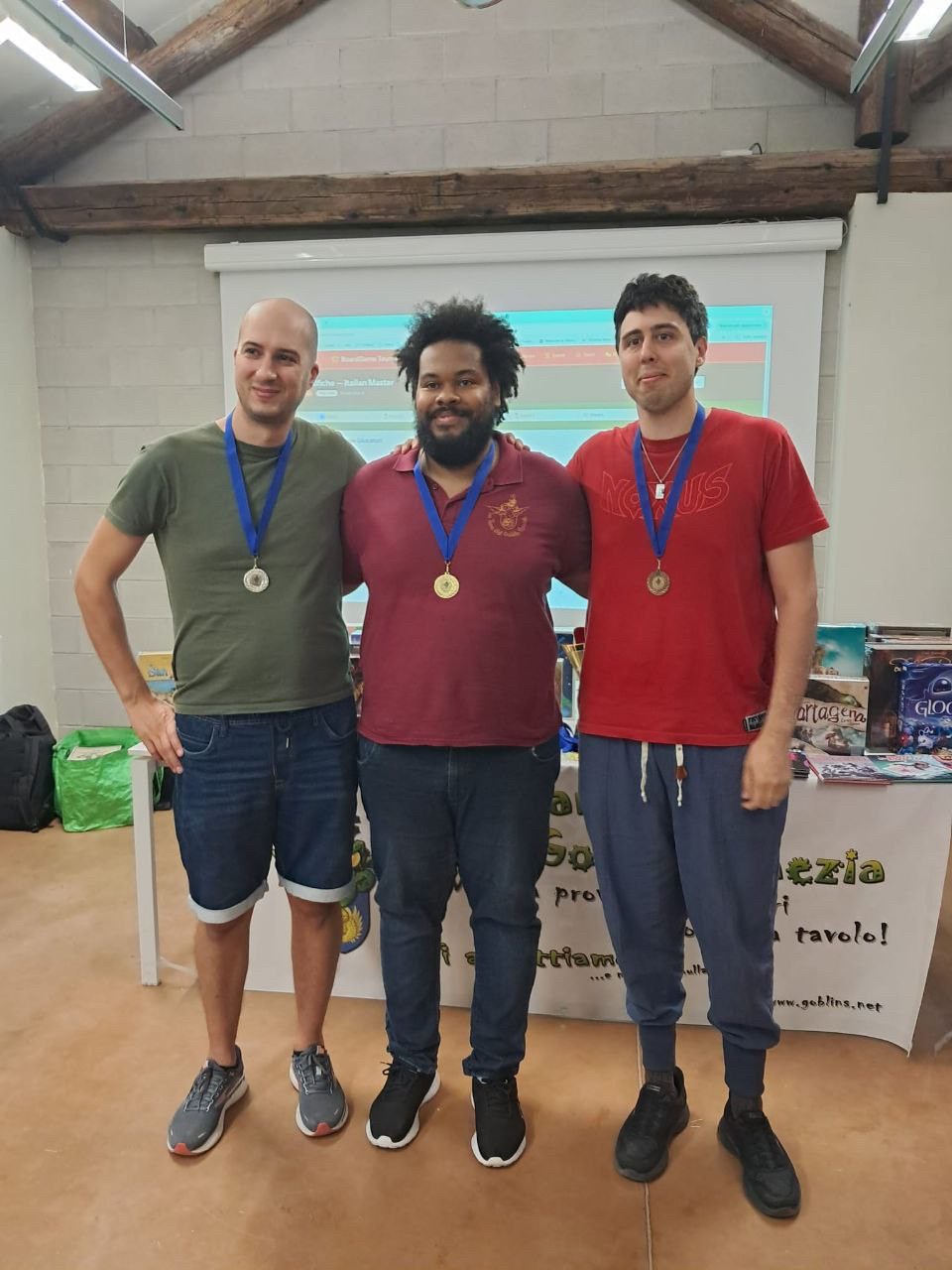 Tre giocatori premiati con la medaglia d'oro davanti al banner della Tana dei Goblin Venezia, Italian Masters 2025.